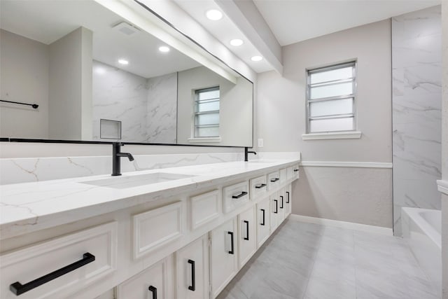 full bath with recessed lighting, double vanity, a wealth of natural light, and a sink