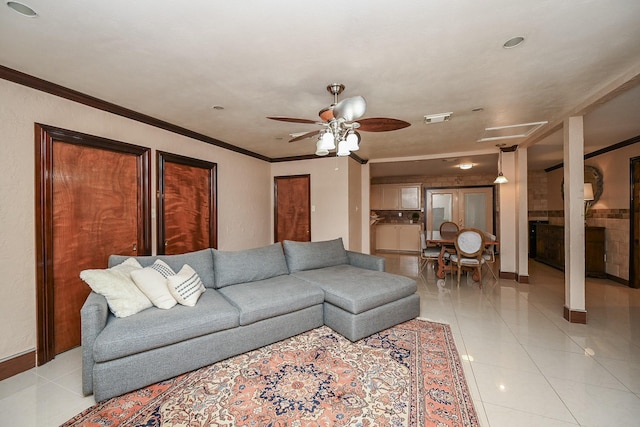 living room with ornamental molding, baseboards, ceiling fan, and light tile patterned floors