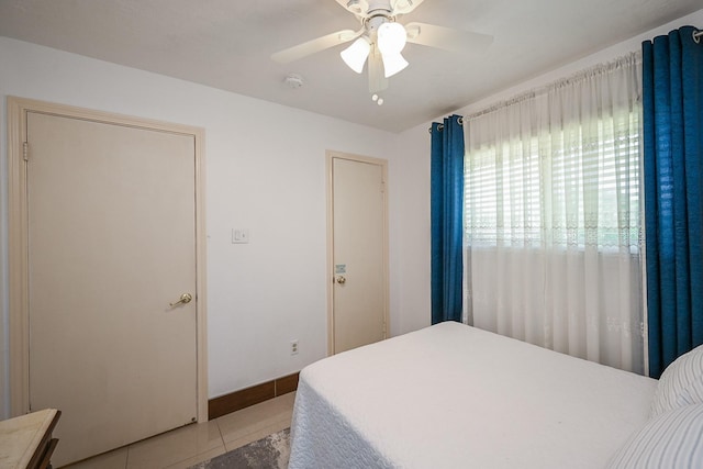 bedroom featuring ceiling fan, baseboards, and light tile patterned floors