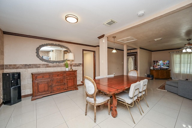 dining room with tile walls, visible vents, ornamental molding, and light tile patterned floors