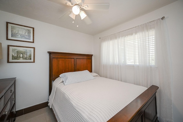 bedroom featuring a ceiling fan, baseboards, and light tile patterned floors