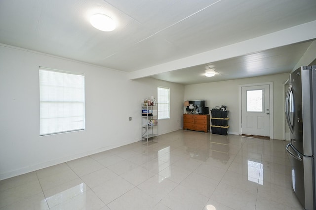 interior space featuring baseboards and light tile patterned flooring