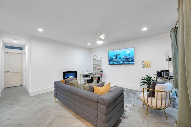 living room featuring a glass covered fireplace, a ceiling fan, baseboards, and recessed lighting