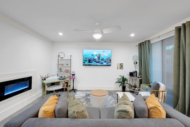 living room featuring recessed lighting, a glass covered fireplace, a ceiling fan, and baseboards