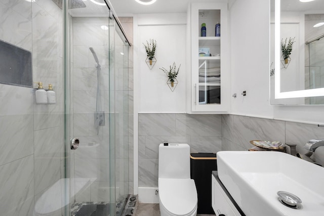 full bathroom with tile walls, vanity, toilet, and a stall shower