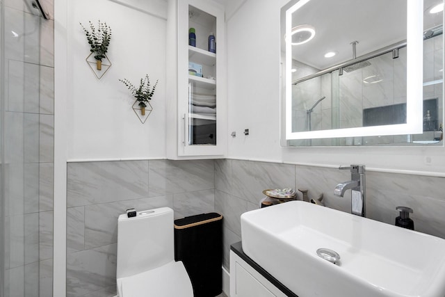 full bathroom with tile walls, toilet, a stall shower, and a sink