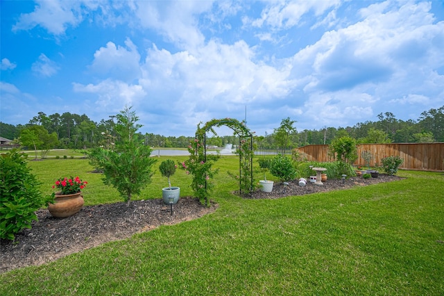 view of yard with fence and a water view
