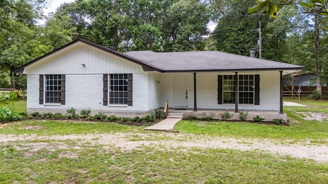 13400 Nicholson Rd, Conroe, TX 77303 - view of front facade with covered porch, brick siding, a front lawn, and a shingled roof