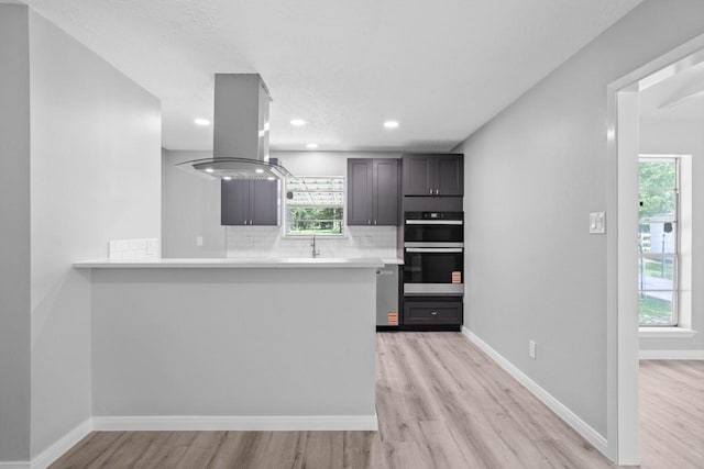 13400 Nicholson Rd, Conroe, TX 77303 - kitchen with island range hood, light wood-style flooring, light countertops, healthy amount of natural light, and recessed lighting