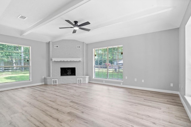 13400 Nicholson Rd, Conroe, TX 77303 - unfurnished living room featuring ceiling fan, wood finished floors, plenty of natural light, and a fireplace