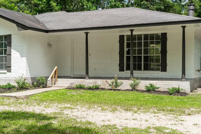 13400 Nicholson Rd, Conroe, TX 77303 - entrance to property featuring brick siding, a shingled roof, a yard, and covered porch