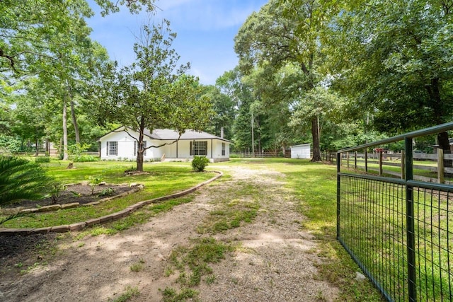 13400 Nicholson Rd, Conroe, TX 77303 - view of yard featuring dirt driveway, view of scattered trees, and an outbuilding