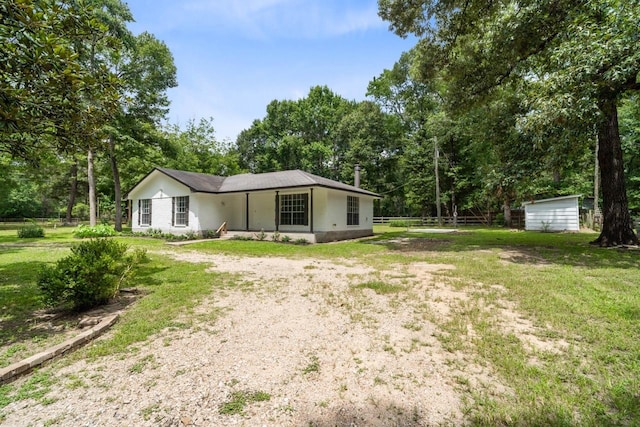 13400 Nicholson Rd, Conroe, TX 77303 - rear view of property with a yard, dirt driveway, a shed, and view of scattered trees