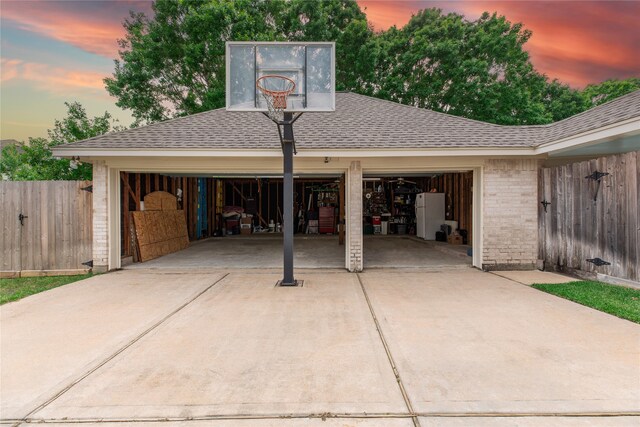 exterior space with a garage, fence, and concrete driveway