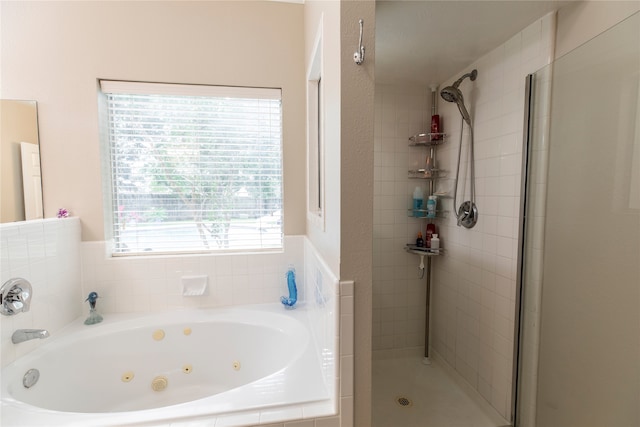 full bathroom featuring a jetted tub and a shower stall