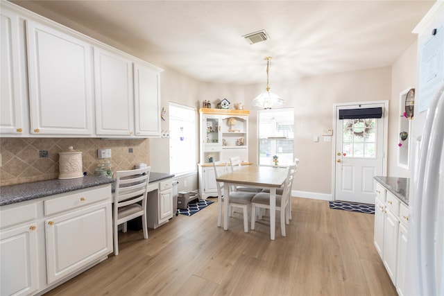 kitchen featuring a notable chandelier, light wood-style flooring, white cabinetry, tasteful backsplash, and visible vents