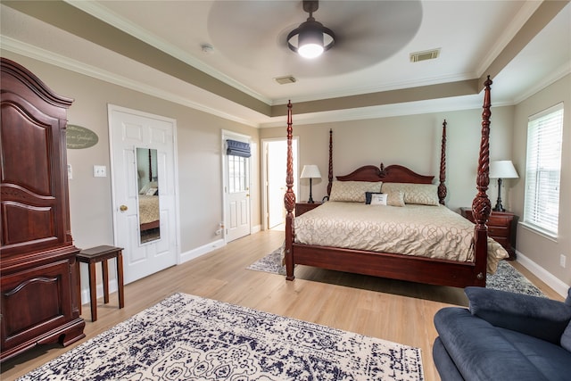 bedroom with visible vents, crown molding, baseboards, light wood-type flooring, and a ceiling fan