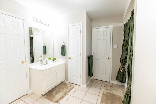 full bathroom with tile patterned floors, baseboards, and vanity