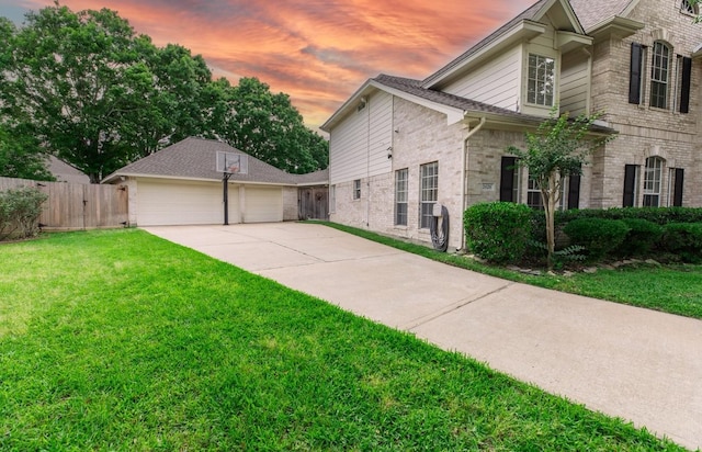 view of property exterior with fence, a yard, and brick siding