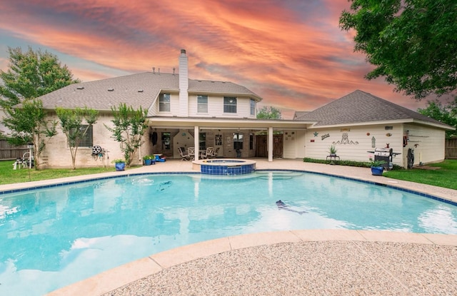 view of pool featuring a patio area, a pool with connected hot tub, and fence