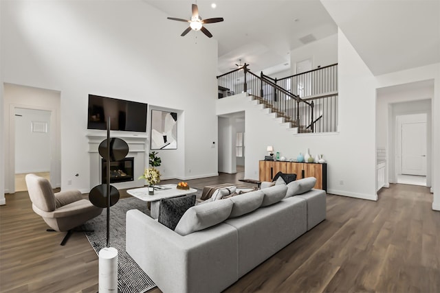 40805 Iver Ln, Magnolia, TX 77354 - living room with a towering ceiling, a glass covered fireplace, wood finished floors, and baseboards