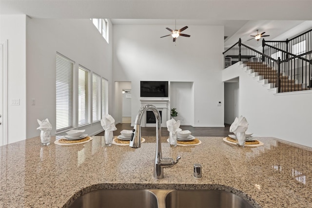 40805 Iver Ln, Magnolia, TX 77354 - kitchen featuring a glass covered fireplace, a ceiling fan, open floor plan, and a sink