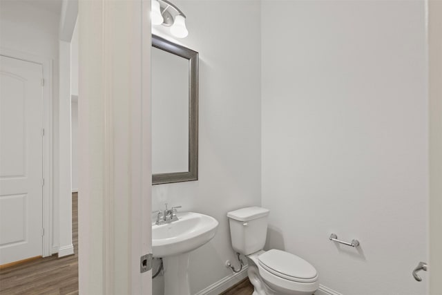 40805 Iver Ln, Magnolia, TX 77354 - bathroom featuring toilet, a sink, wood finished floors, and baseboards