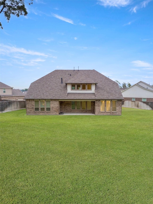 40805 Iver Ln, Magnolia, TX 77354 - rear view of house featuring brick siding, a yard, a shingled roof, and fence