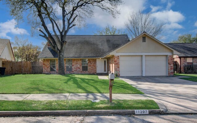 11307 Birdwing Ln, Houston, TX 77067 - view of front of home featuring concrete driveway, a front lawn, an attached garage, fence, and brick siding