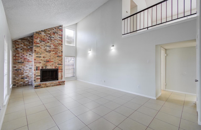 11307 Birdwing Ln, Houston, TX 77067 - unfurnished living room with high vaulted ceiling, a brick fireplace, a textured ceiling, and light tile patterned floors