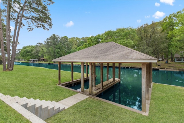 view of dock with a yard, boat lift, and a water view