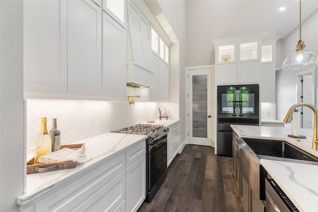 kitchen with dark wood-style floors, custom exhaust hood, white cabinetry, gas stove, and refrigerator with glass door