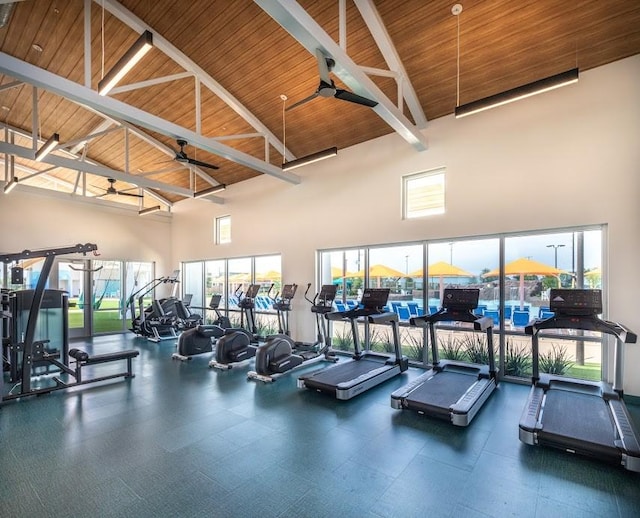 gym with a towering ceiling, wooden ceiling, and ceiling fan