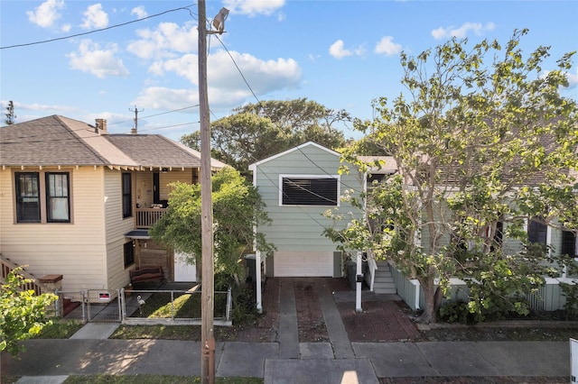 1003 Sealy St, Galveston, TX 77550 - view of front of home with a gate, an attached garage, fence, driveway, and a shingled roof