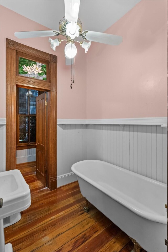 1003 Sealy St, Galveston, TX 77550 - full bathroom featuring a wainscoted wall, wood finished floors, a freestanding tub, and ceiling fan