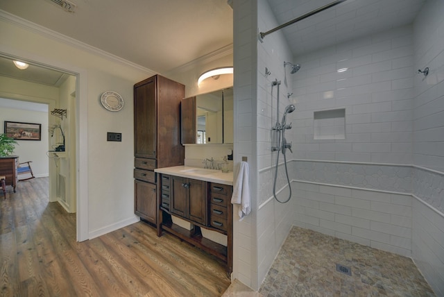 bathroom with walk in shower, crown molding, vanity, and wood finished floors