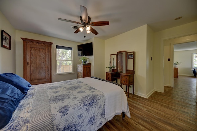 bedroom with dark wood finished floors, baseboards, and a ceiling fan