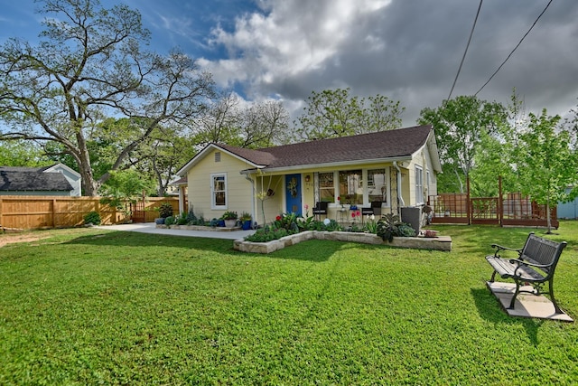 rear view of house featuring fence, a yard, and covered porch