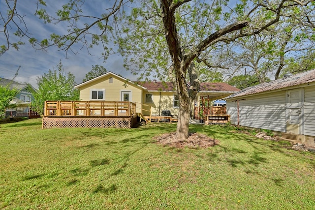 rear view of property featuring a wooden deck and a yard