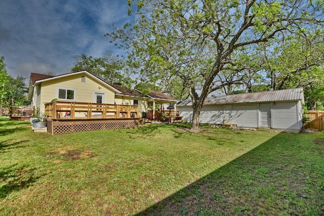 rear view of house with a wooden deck, a lawn, fence, and an outdoor structure