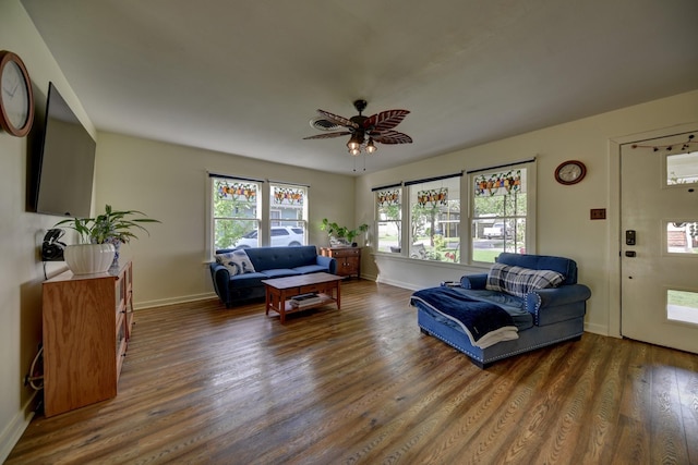 living room featuring baseboards, a ceiling fan, and wood finished floors