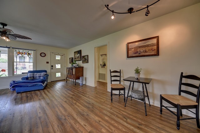 living area with ceiling fan, baseboards, wood finished floors, and visible vents