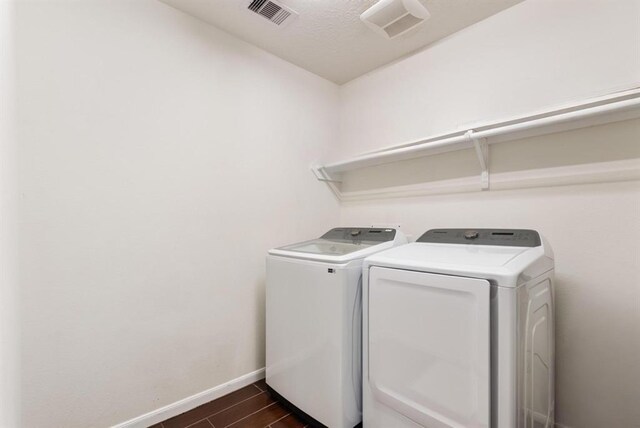 8206 Caldera Ln, Cypress, TX 77433 - washroom featuring dark wood-style floors, laundry area, washing machine and dryer, baseboards, and visible vents