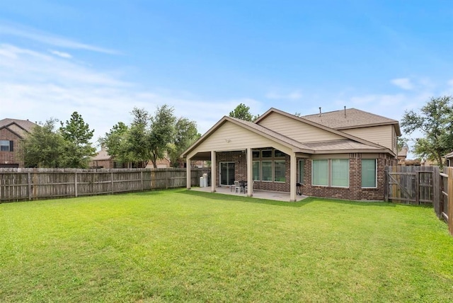 8206 Caldera Ln, Cypress, TX 77433 - rear view of house featuring a fenced backyard, brick siding, a yard, and a patio