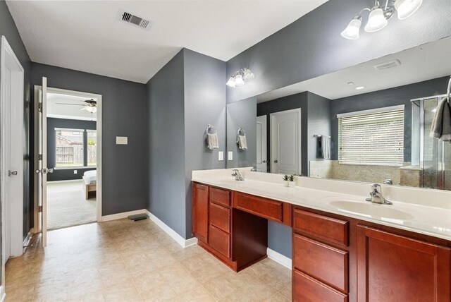 8206 Caldera Ln, Cypress, TX 77433 - ensuite bathroom featuring double vanity, visible vents, a ceiling fan, a sink, and baseboards