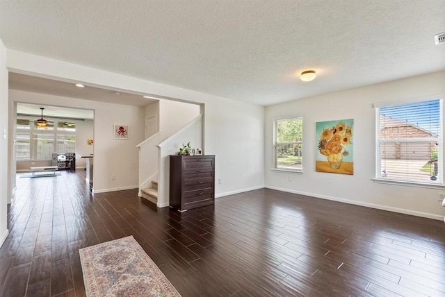 8206 Caldera Ln, Cypress, TX 77433 - unfurnished living room with plenty of natural light, baseboards, a textured ceiling, and stairs