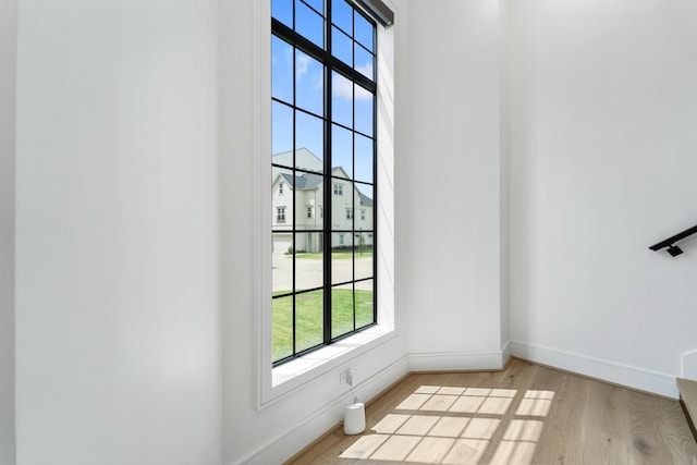 doorway with baseboards and wood finished floors