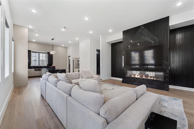 948 Blackshire Ln, Houston, TX 77055 - living area featuring light wood-style floors, baseboards, a high end fireplace, and recessed lighting