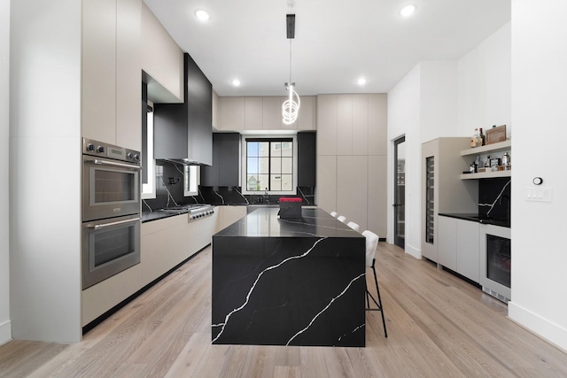 948 Blackshire Ln, Houston, TX 77055 - kitchen with modern cabinets, appliances with stainless steel finishes, a center island, light wood-style floors, and recessed lighting