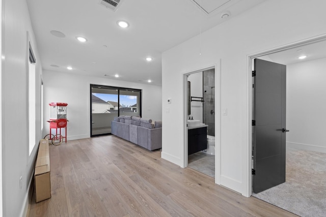 hallway with visible vents, baseboards, attic access, recessed lighting, and light wood finished floors